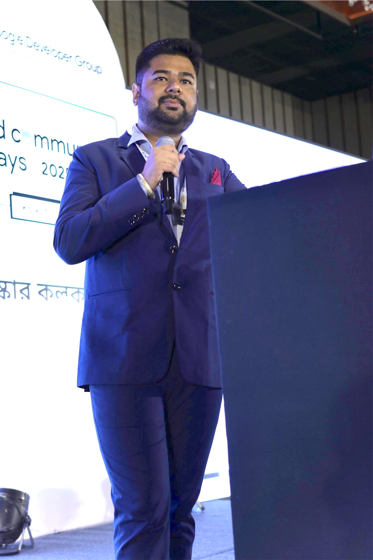Harshit Jaiswal speaking at a lectern at GDG Cloud Community Days, Kolkata